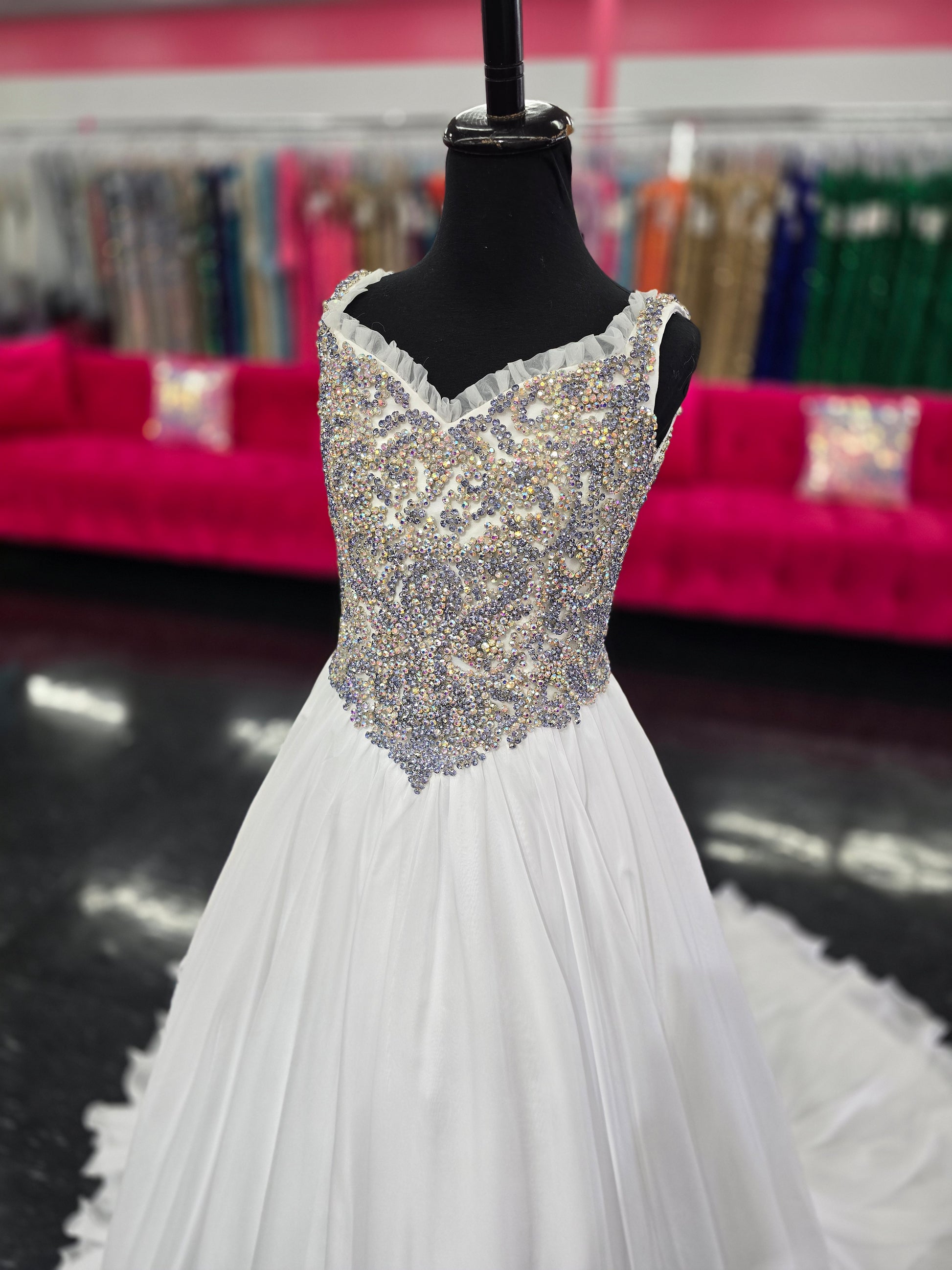 Experience the luxurious elegance of the Samantha Blake 1127 Pageant Dress. Made with soft, lightweight chiffon, this A-line ballgown will have your little girl feeling like a true princess. The crystal embellished bodice and ruffle trim neckline add a touch of sparkle and charm. Perfect for any pageant or special occasion.