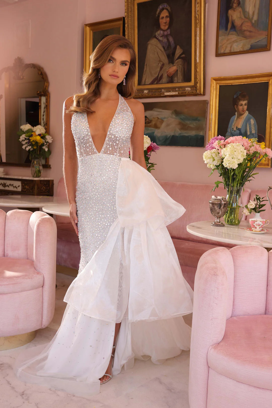 This Ava Presley 40064 dress features a sheer crystal halter design with a formal ruffle overskirt and a slit. Perfect for pageants and formal events, this gown exudes elegance and sophistication. With its intricate details and high-quality materials, it is sure to make you stand out and feel confident.