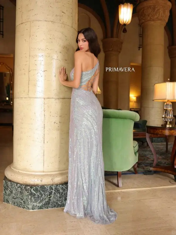 Elevate your formal pageant look with the Primavera Couture 4152 gown. Its lace-up back, high slit, and beaded sequin details create a stunning and fitted silhouette. The asymmetrical design adds a unique touch to this elegant dress. Shine like a star on stage with this beautifully crafted gown.