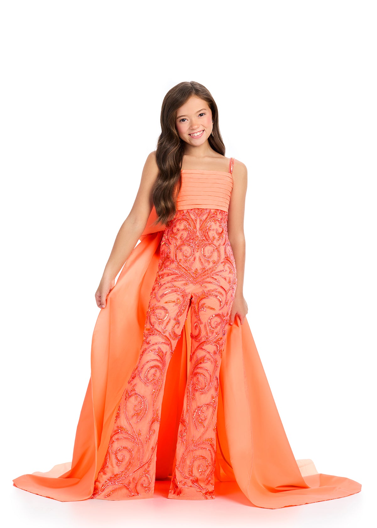 Introducing the Ashley Lauren Kids 8292 Girls Beaded Pageant Jumpsuit – the perfect combination of fun, fashion, and formal wear. This jumpsuit features intricate beadwork and a bow cape overskirt for added flair, making your little one stand out on stage. Sequin details add a touch of sparkle to this elegant piece. Look fierce in this fun fashion jumpsuit! The spaghetti strap taffeta gown is complete with a fully beaded design, a fabulous train and an oversized bow giving you the perfect amount of sass and