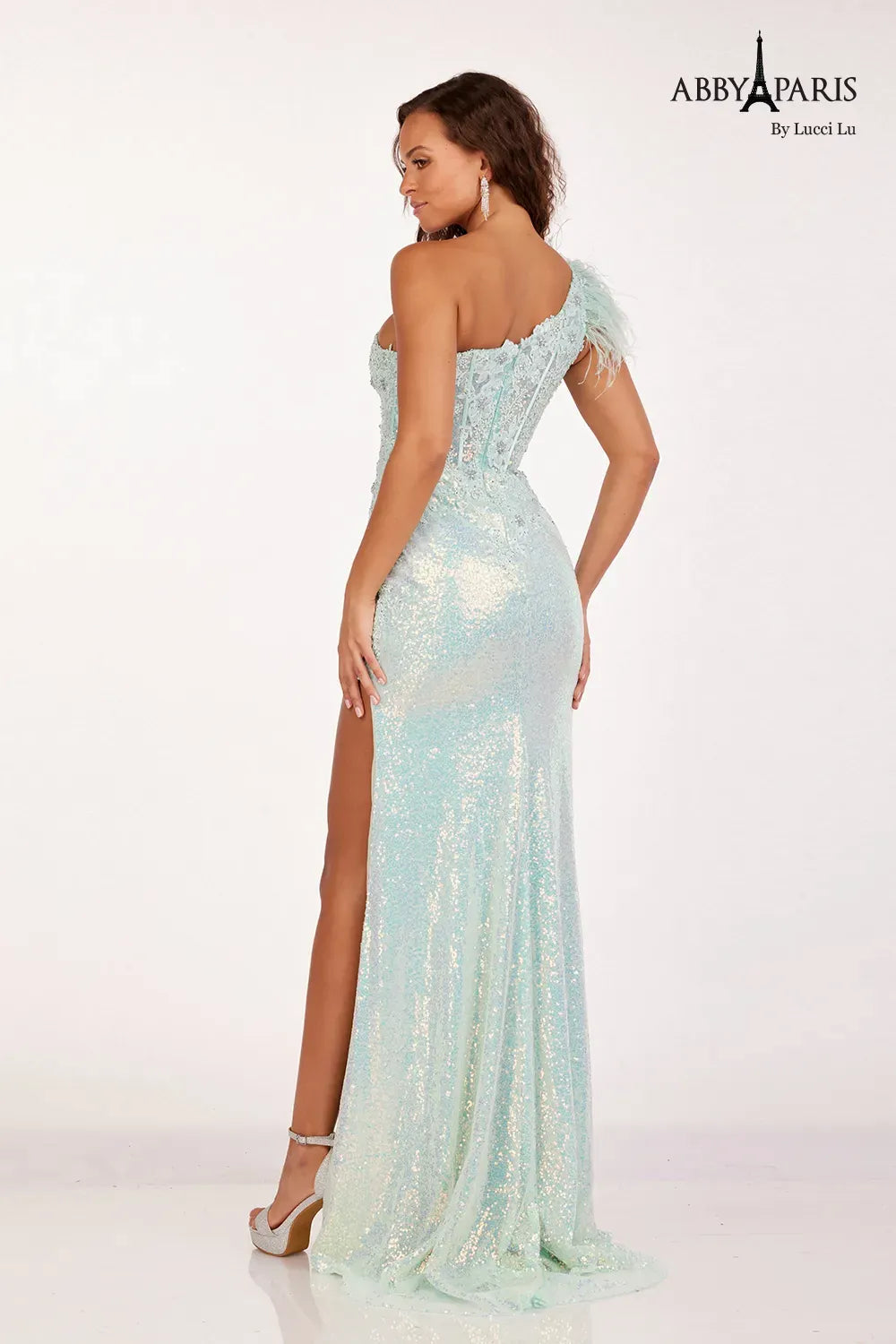 Make a statement at prom with the Abby Paris 90256 dress. This one-shoulder gown features intricate lace and stunning sequin embroidery,. The high slit reveals just the right amount of skin, while the feather detailing adds a touch of glamour. Perfect for a night to remember.  Sizes: 0-18  Colors: Mint, Lilac