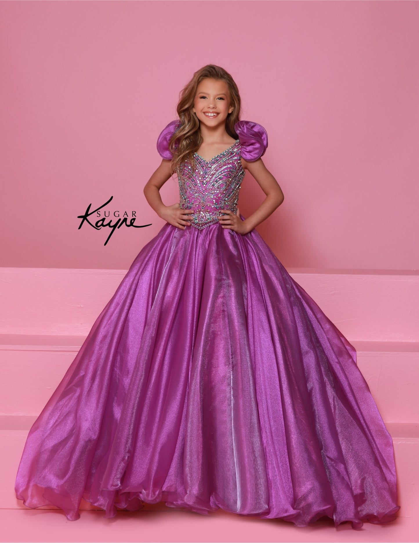 Bring out her inner beauty with this Sugar Kayne C334 Girls Pageant Dress. This luxurious dress is made from iridescent organza and features a sweetheart neckline and long ball gown skirt. Perfect for any special occasion.&nbsp;Transform into a twinkling starlet with this Metallic Organza Gown. The beaded bodice adds a touch of sparkle to this enchanting ensemble. The delicate ruffle sleeves create a charming look!

Color:&nbsp;Hot Pink Multi, Mint Multi, White Multi, Purple Multi

Size:&nbsp;2, 4, 6, 8, 10