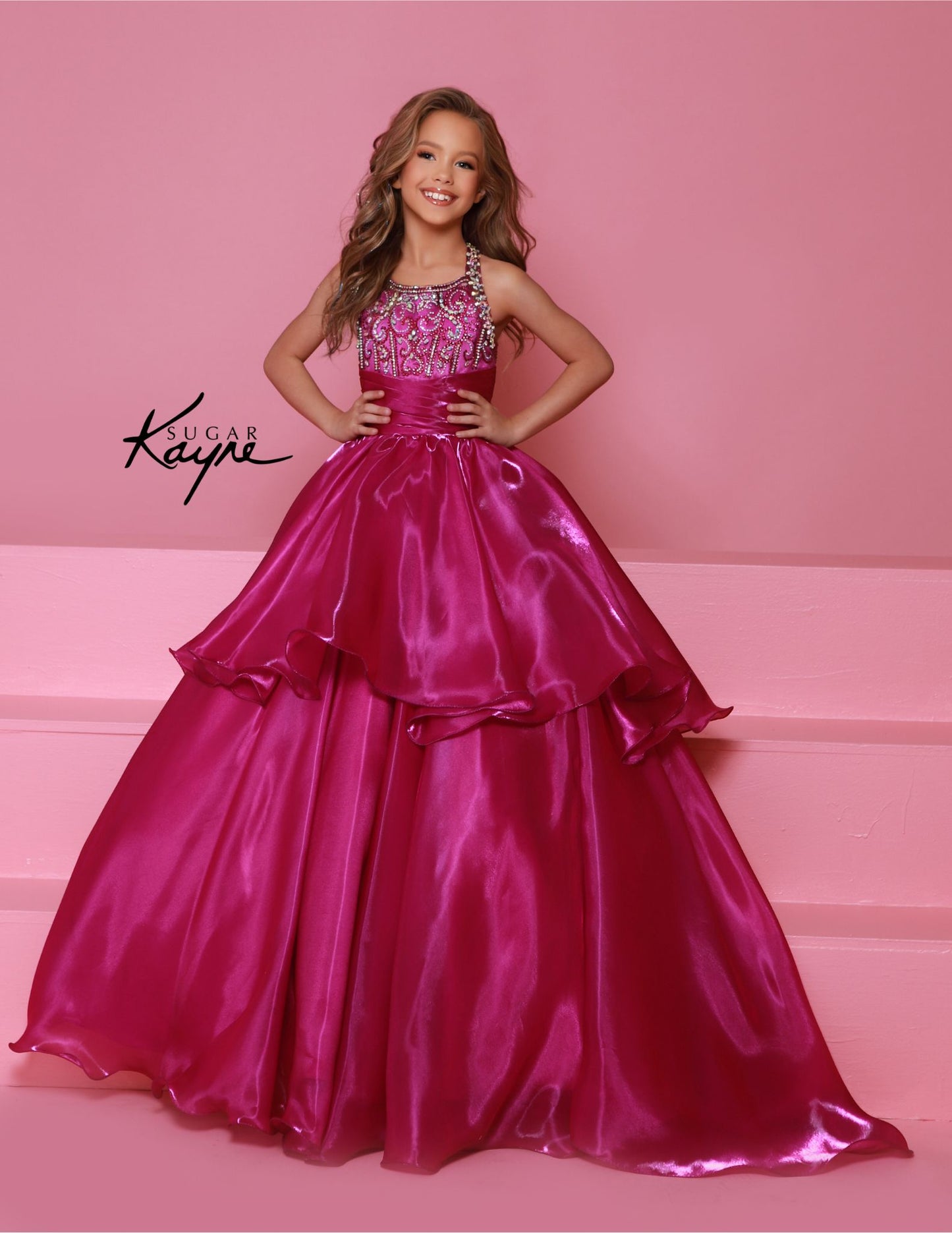 Experience the ultimate in luxury and style with the Sugar Kayne C378 Shimmer Girls Pageant Dress. The A Line Layer design is enhanced with a beaded bodice and a train for added drama. The high neck adds a touch of elegance, making this dress perfect for any pageant or formal event. Embrace your inner star with this show-stopping mirror organza ballgown. The sophisticated, beaded neckline and shimmering fabric ensure you’ll mesmerize the judges with your poise and elegance.

Sizes: 2-16

Colors: Cherry, Mag