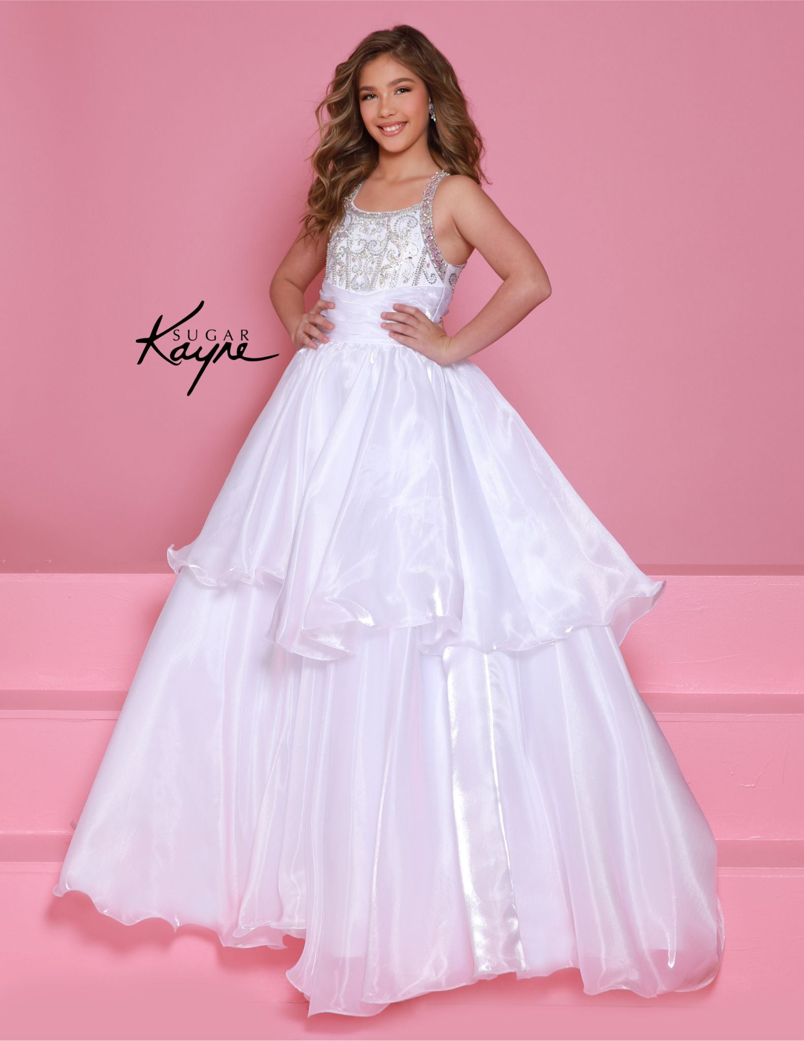 Experience the ultimate in luxury and style with the Sugar Kayne C378 Shimmer Girls Pageant Dress. The A Line Layer design is enhanced with a beaded bodice and a train for added drama. The high neck adds a touch of elegance, making this dress perfect for any pageant or formal event. Embrace your inner star with this show-stopping mirror organza ballgown. The sophisticated, beaded neckline and shimmering fabric ensure you’ll mesmerize the judges with your poise and elegance.

Sizes: 2-16

Colors: Cherry, Mag