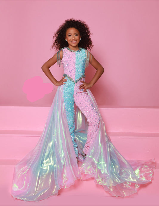 Get your little one ready to stand out in style with Sugar Kayne's C386 Girls Velvet Sequin Pageant Jumpsuit. This fun and fashionable piece features a stunning velvet fabric with shimmering sequin details, perfect for any pageant or special occasion. The fringe overskirt adds a touch of playful flair, making your child the center of attention. This sequin stretch velvet two-tone jumpsuit features crystal embellishments and beaded shoulder fringe. An iridescent organza cape flows from the waist, adding a dr