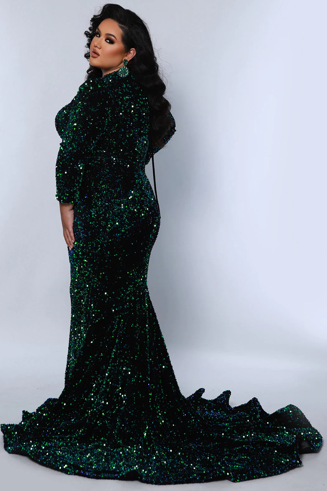 This Sydneys Closet dress is perfect for special occasions. It features a figure-hugging mermaid silhouette, a train, and a V-neckline with long sleeves. The fabric is a luxurious blend of sequin and velvet for a stunning look. The corset ensures a perfect fit for plus size wearers. Our Clutch plus size sequin Mermaid gown guarantees you'll dazzle everyone at a Pageant, Prom 2024 or any black-tie event.