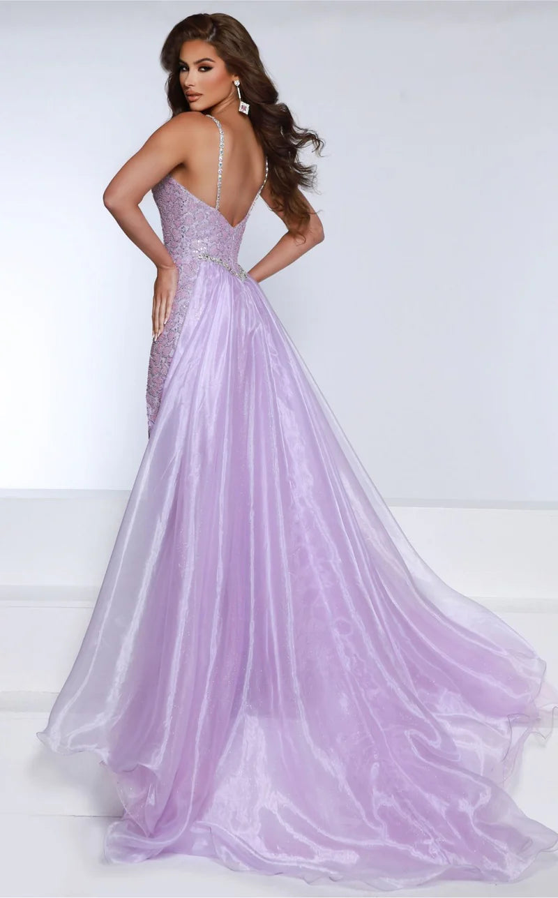 This Johnathan Kayne DKS2 dress features intricate beading and a fitted silhouette for a glamorous pageant look. The overskirt and slit add elegant movement, while the crystals add a touch of sparkle. Perfect for formal events or pageants. Radiate glamour in this Beaded Glitter Mesh gown featuring a glitter tulle organza overskirt,