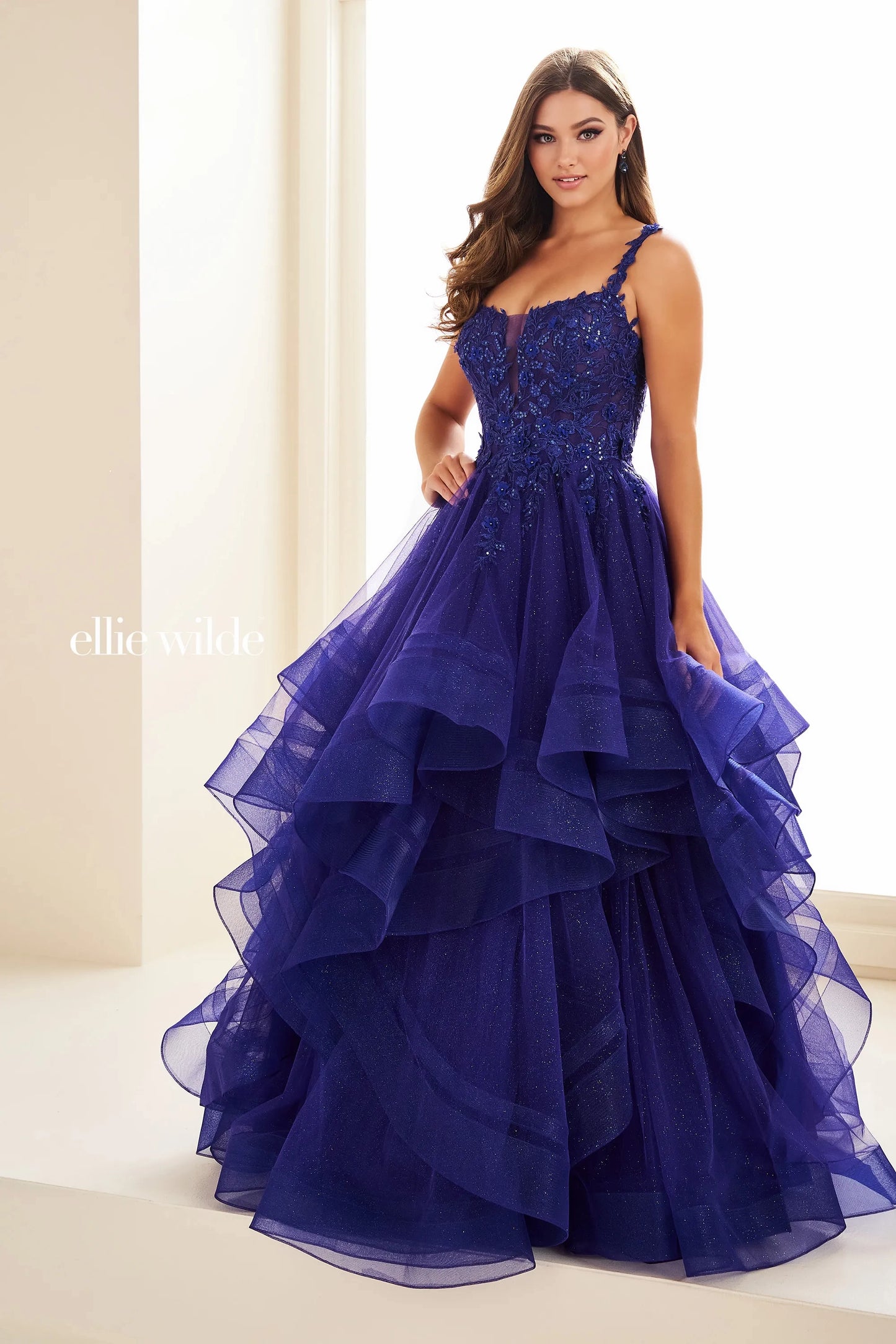 Expertly crafted by Ellie Wilde, the EW36035 dress boasts a sheer lace shimmer, ruffle details, and a corset-style bodice. Completed with a sequin layer for added sparkle, this ballgown will make you stand out at any prom or formal event. Elevate your style and confidence with this stunning dress.