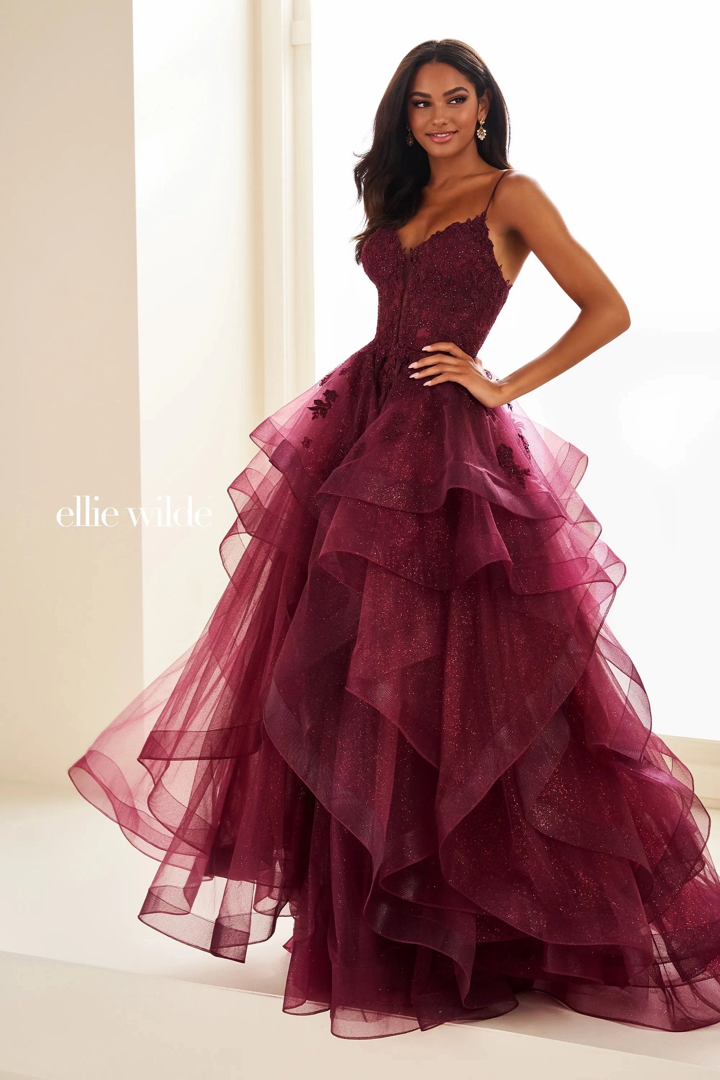 This Ellie Wilde EW36203 prom dress dazzles with a sheer lace corset bodice, ruffle A-line skirt, and shimmering fabric. Create an elegant silhouette with the figure-flattering corset and add a touch of romance with the feminine ruffle detailing. Perfect for a formal evening event, this dress is sure to turn heads.