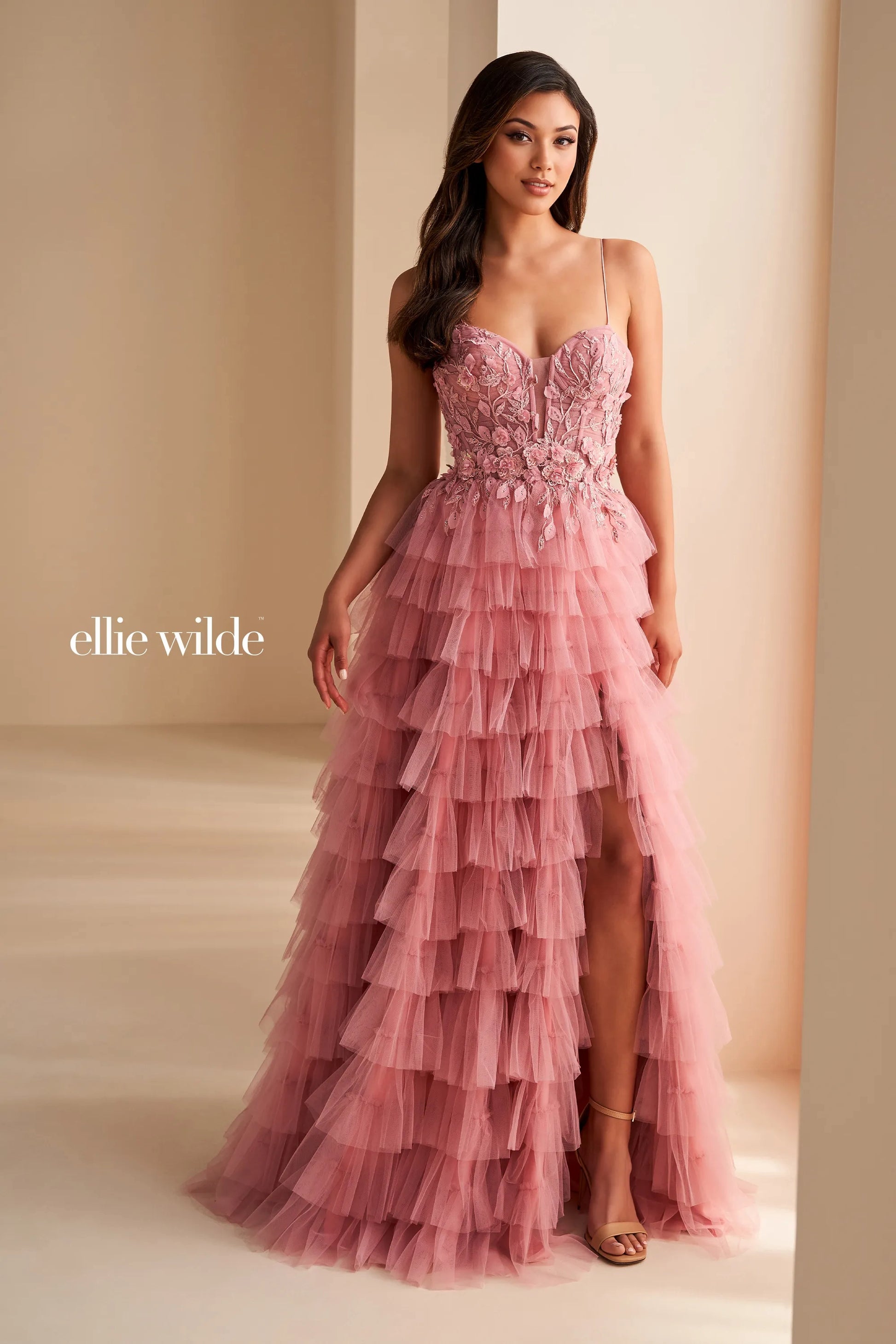 Elevate your prom night in this stunning Ellie Wilde EW36223 prom dress. The long tulle layers create a flowing silhouette, while the sheer lace corset adds a touch of delicate beauty. Complete with a dramatic maxi slit, this formal gown is perfect for making a lasting impression.