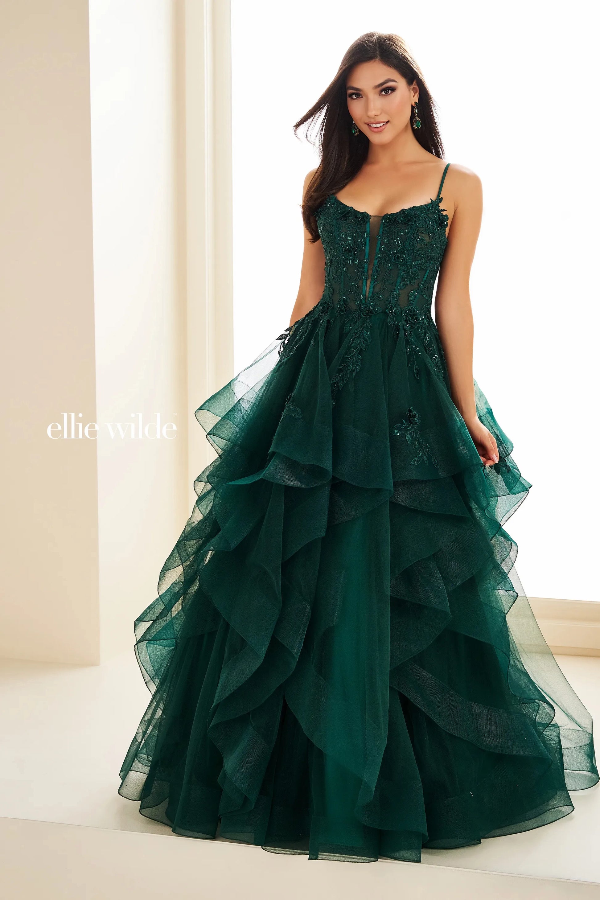 Step into elegance with the Ellie Wilde EW36225 Sheer Lace Corset Ball Gown. Featuring a stunning sheer lace bodice and layered corset, this formal evening gown is perfect for prom or any special occasion. Make a statement in this luxurious and exclusive dress, designed to make you feel like a work of art.